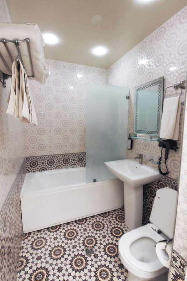 A bathroom with a bathtub, sink, and toilet.