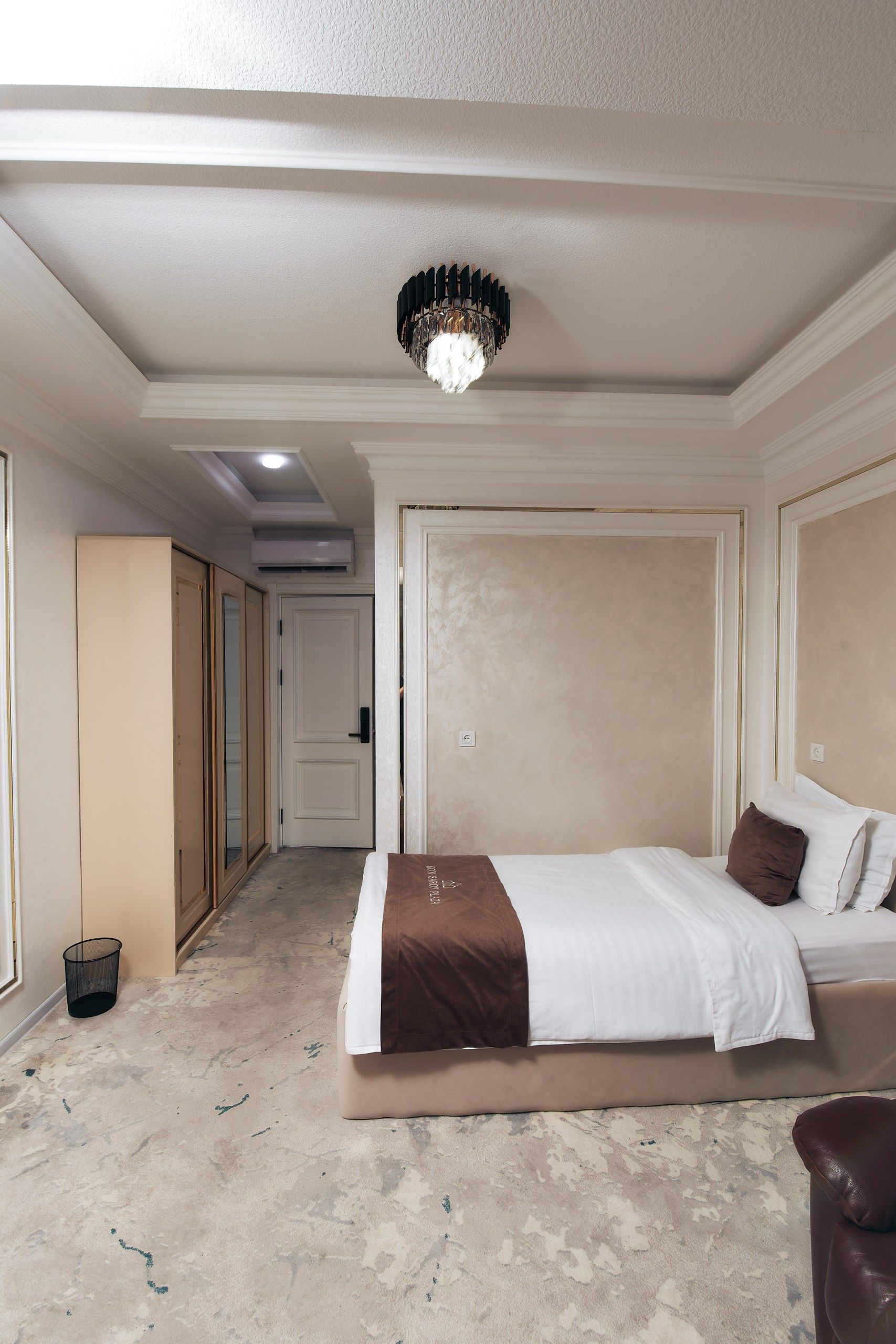 Une chambre d’hôtel avec un lit, une table de chevet, une lampe et une vue sur le couloir.