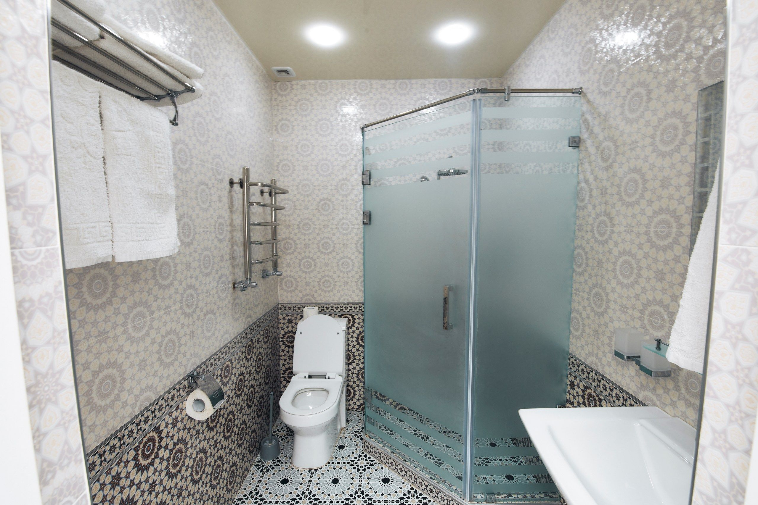 Une salle de bain avec une douche à parois de verre, des toilettes et un lavabo.