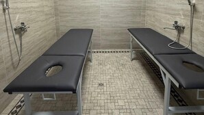 A clinical room with two examination tables, a tiled floor, and a ceiling light. - KO'K SAROY PLAZA (Samarkand)