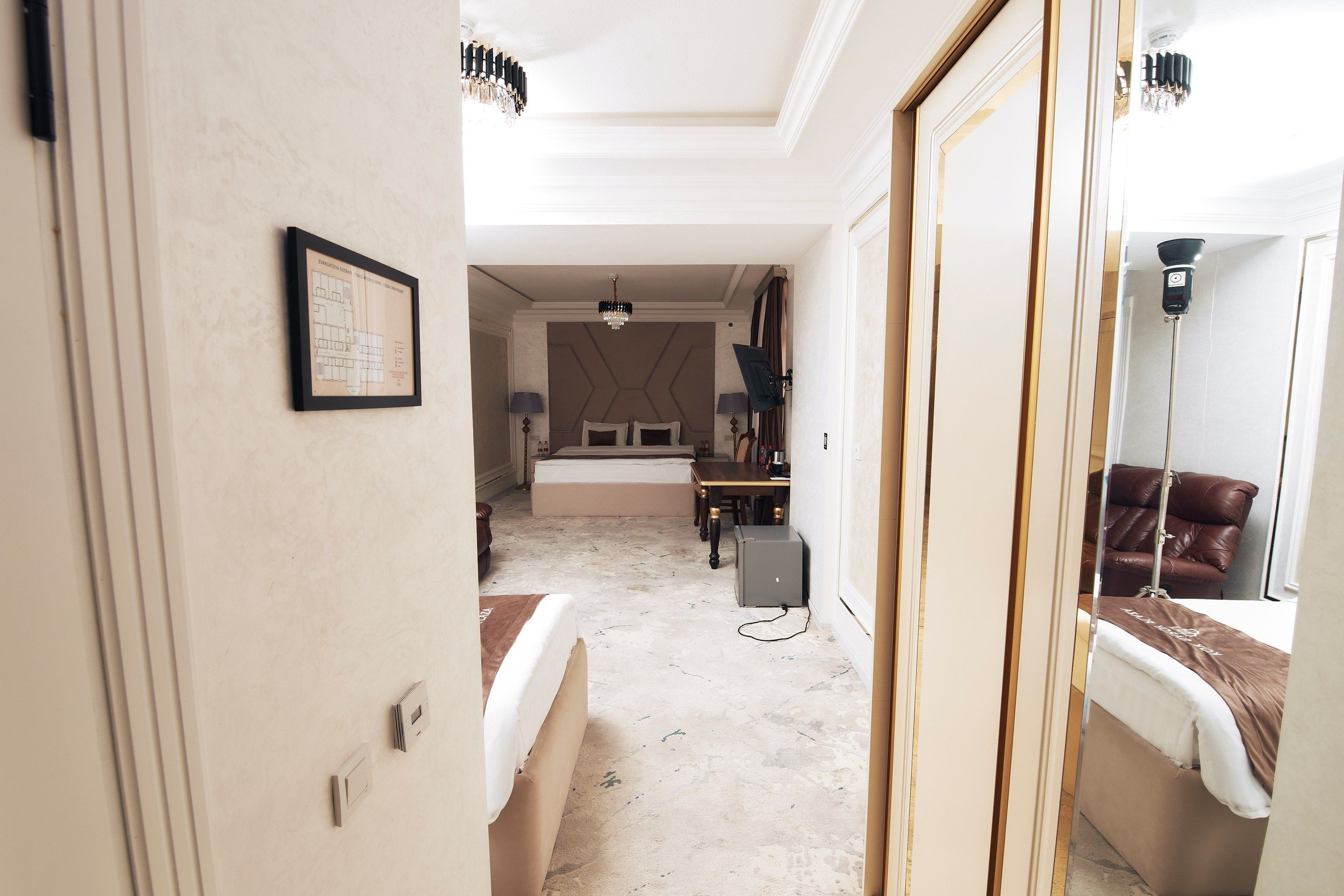 Una habitación de hotel con una cama, un escritorio, una silla, una lámpara y un espejo.