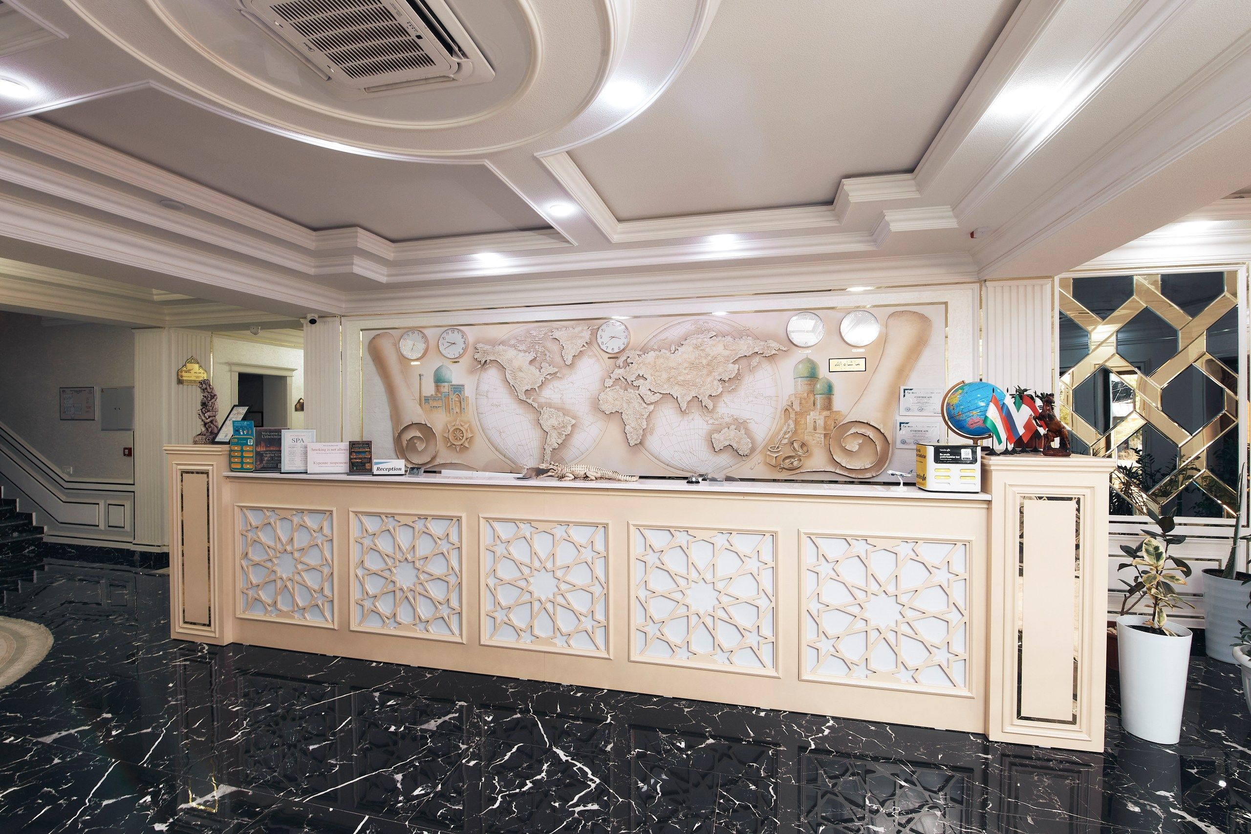 A reception desk with a world map, clocks, and a globe.
