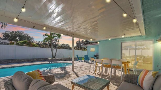 Un espace extérieur abrité comprenant une piscine, des sièges et une vue sur le paysage environnant.