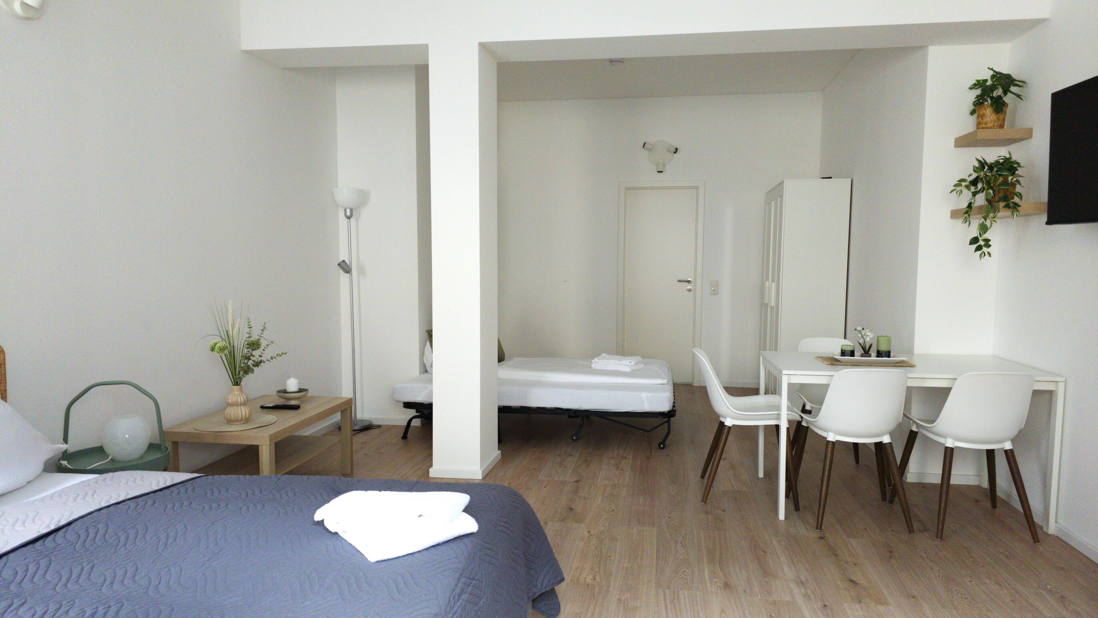 Une chambre d’hôtel moderne équipée d’un lit, d’un bureau, de chaises et d’une salle de bain.