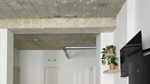 Een moderne keuken met een zwarte koelkast, witte kasten, en een eethoek met een witte tafel en stoelen.