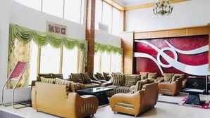 A spacious lobby with a modern sofa arrangement, a large abstract painting on the wall, and a chandelier. - Royal Grand By Skua World  (Manali)