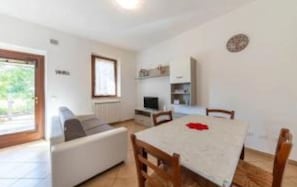 A compact living space with a kitchenette, a dining area, and a sofa.