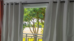 A room with a large window, white curtains, and a view of trees and a fence outside. - Lovely 4-bed House in Palmira Valle del Cauca (Palmira)