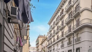 A narrow street with buildings on either side, some with balconies and air conditioning units. - Hotiday Room Collection - Napoli Sant’Arcangelo  (Naples)