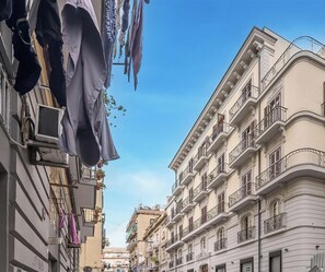 A narrow street lined with multi-story buildings, some with balconies and air conditioning units. - Hotiday Room Collection - Napoli Sant’Arcangelo  (Naples)