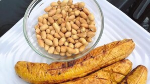 A white plate with grilled bananas and a bowl of peanuts. - Humuplace Sleeps 4 With Garden (Birmingham)