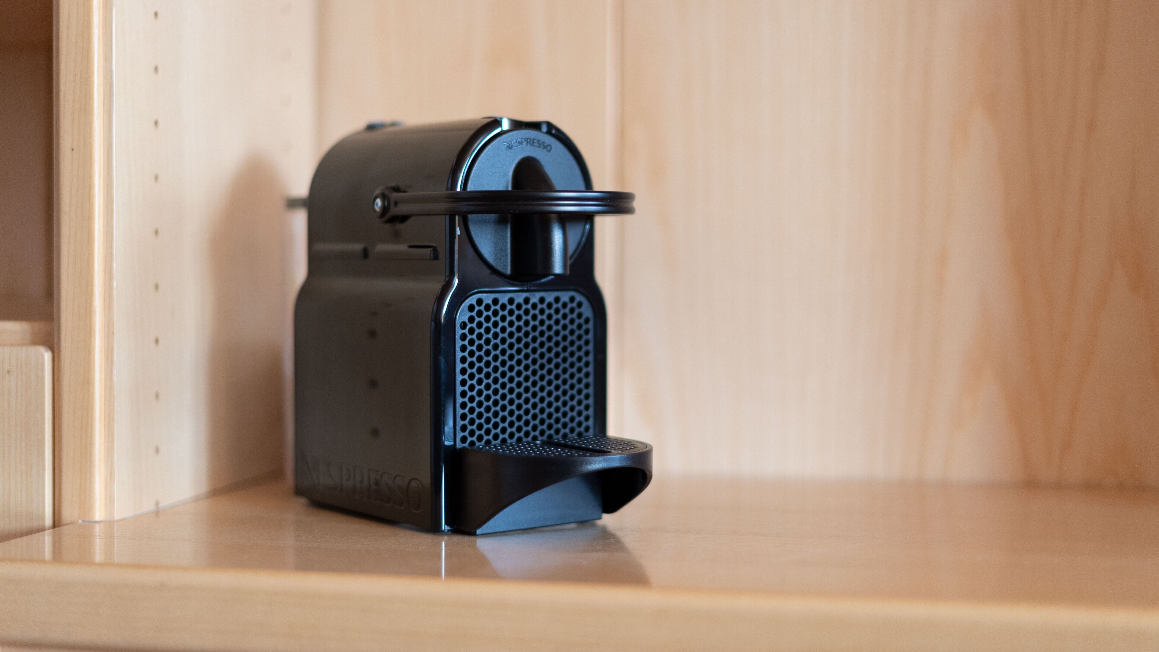 A Nespresso coffee machine on a wooden shelf.