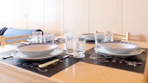A dining table set with plates, bowls, glasses, and cutlery. - Italianway - Bruni 2 (Bormio)
