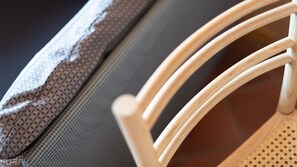 Gros plan d’une chaise dotée d’un dossier en tissu ajouré et d’un revêtement en tissu à motifs recouvrant une partie de l’assise.