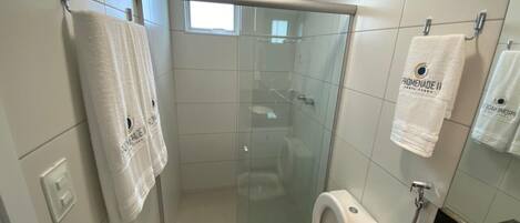 A modern bathroom with a glass-enclosed shower, a toilet, and a sink.