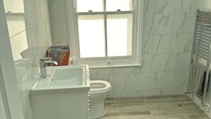 Ein Badezimmer mit Toilette, Waschbecken und Fenster.