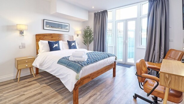 Ein Hotelzimmer mit einem hölzernen Bett, einem Schreibtisch und einem Stuhl.