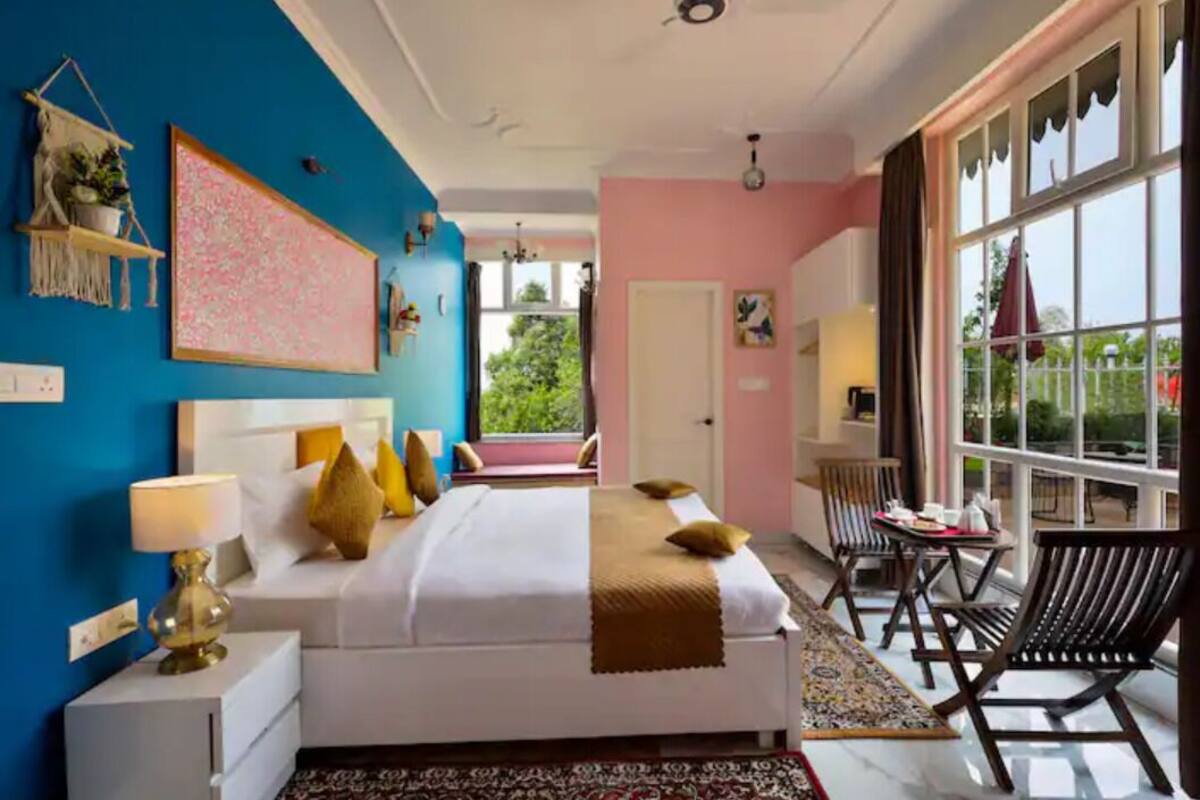 A bedroom with a bed, bedside tables, a window, and a view of the outdoors.
