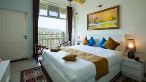 A hotel room with a large bed, a painting, a view through the window, and a balcony. - The Crosswoods Three (Kosiyakutoli)
