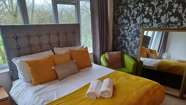 A neatly made bed with a headboard, multiple pillows, and a yellow blanket. - Lovely 1-bed Apartment in Birmingham (Birmingham)