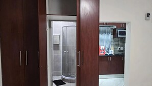 A modern kitchen with a microwave, toaster, and a small refrigerator. - Goshen Lodge Spencer (Cape Town)