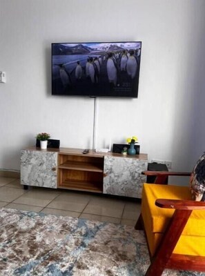 Relax in this cozy living space with a flat-screen TV, entertainment center, and comfortable seating area.