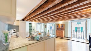 Una cocina amplia con techo de madera, una isla grande y vistas al exterior.