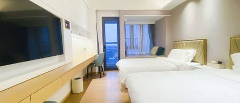 Une chambre d’hôtel avec deux lits, une télévision, un bureau et une vue sur le balcon.