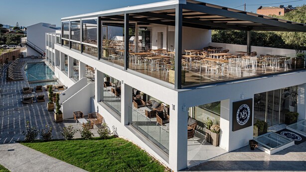 Ein modernes Gebäude mit Dachterrasse, Sitzgelegenheiten im Freien und einem Swimmingpool.