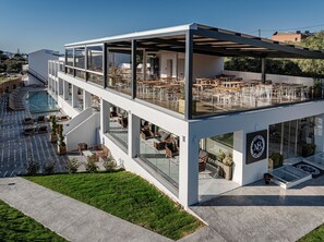 A modern building with a rooftop terrace featuring outdoor seating and a swimming pool. - Magique Bleu Suites (Zakynthos)