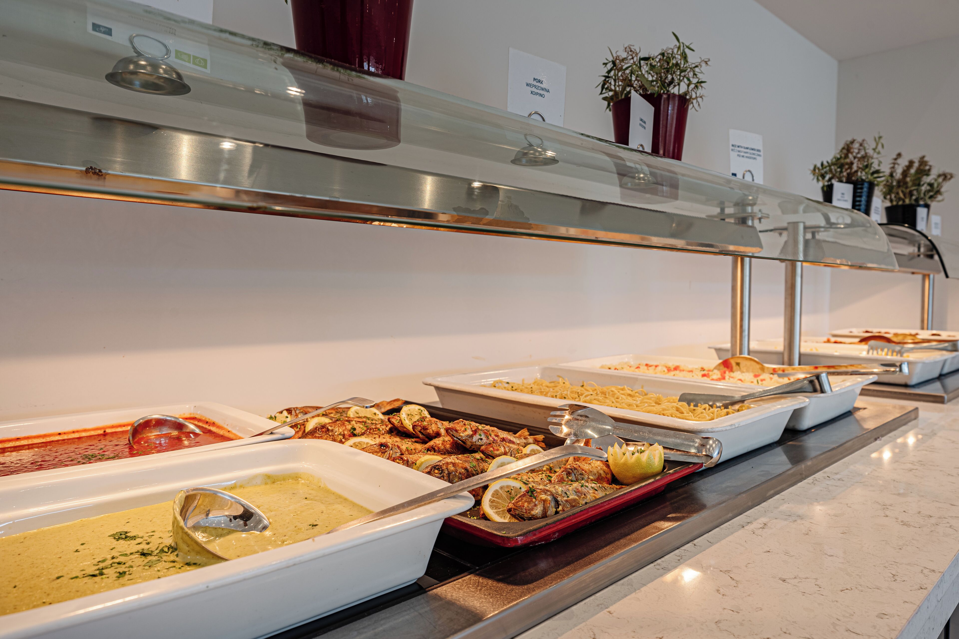 A buffet with various dishes including seafood, pasta, and a creamy soup.