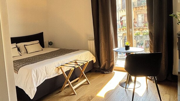A bedroom with a bed, a small table, and a chair. - Olivuzza 27 (Palermo)