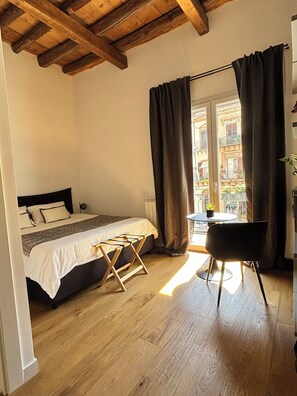 Une chambre à coucher avec un lit, une petite table et une chaise.