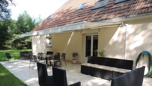Un patio al aire libre con una mesa de comedor, sillas y un sofá.