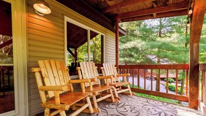 A porch with wooden rocking chairs and a patterned rug. - 2Q Cabin near Leesville Lake ~Pets welcome~ (Carrollton)