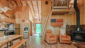 A wooden interior with a kitchen, dining area, and seating. - 2Q Cabin near Leesville Lake ~Pets welcome~ (Carrollton)
