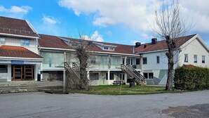 A row of residential buildings with a staircase leading to a second floor, a small outdoor seating area, and a clear sky. - Solvoll (Tønsberg)