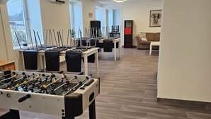 A spacious indoor area with multiple foosball tables, a sofa, and a coffee table. - Solvoll (Tønsberg)
