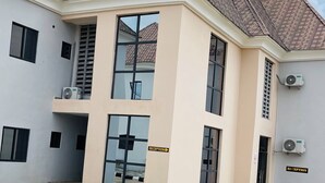 A modern building with a reception area, large windows, and air conditioning units. - Come Inn Hotel (Abuja)