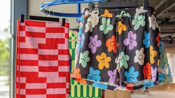 A rack with various patterned towels and shorts.