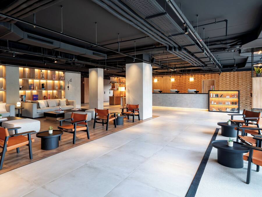Un vestíbulo moderno con una zona de estar, una recepción y una exhibición de libros y objetos decorativos.