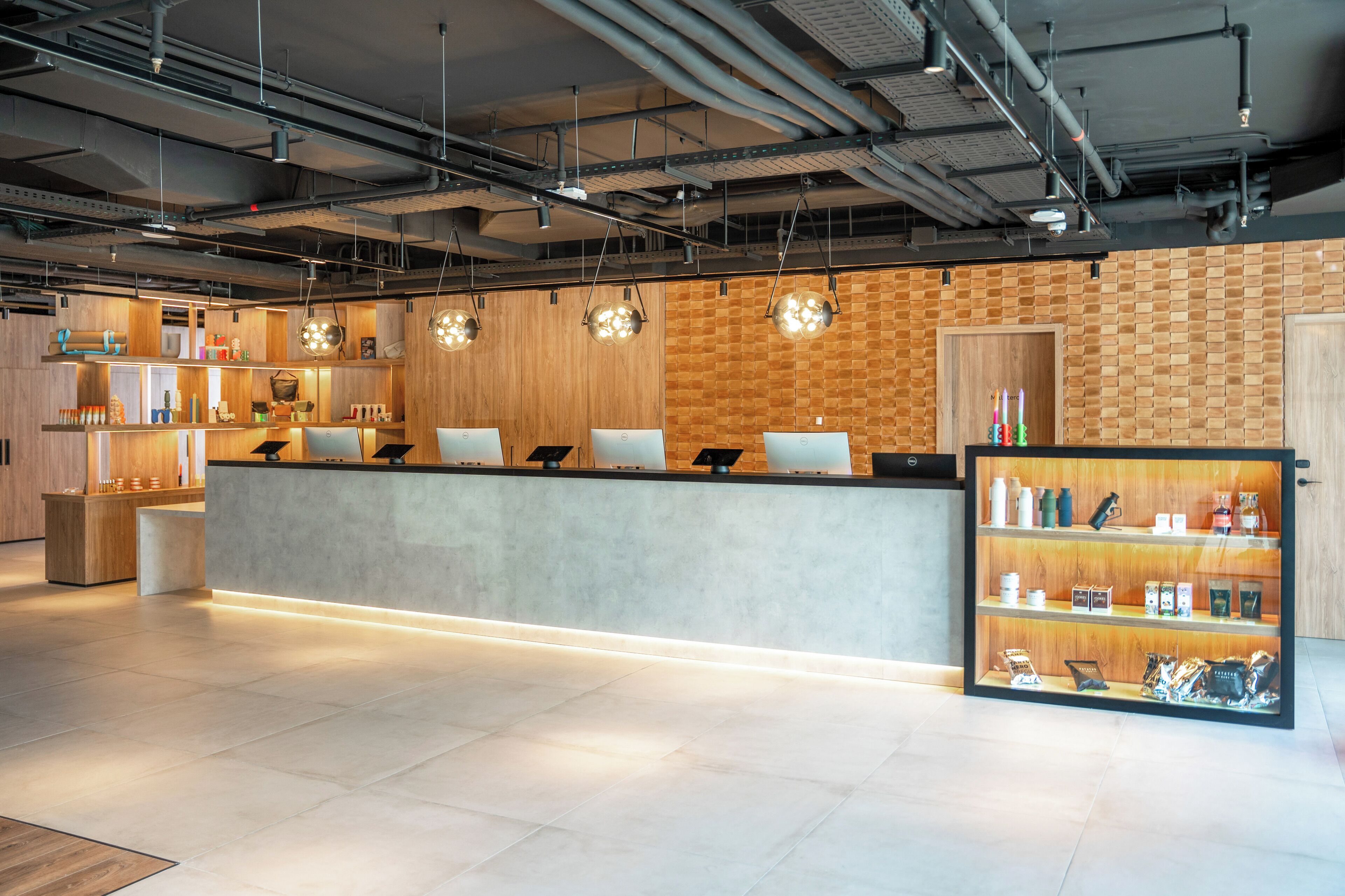 A modern reception area with a wooden wall, a reception desk, and a display case with various items.