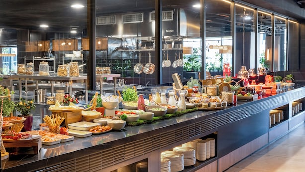 A buffet with various food items and utensils. - INNSiDE by Meliá Madrid Valdebebas (Madrid)