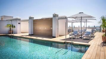 Piscina a l'aire lliure, para-sols i gandules