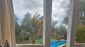 A breakfast table with a view of a swimming pool and trees. - Manzal Lahbab (Marrakech)