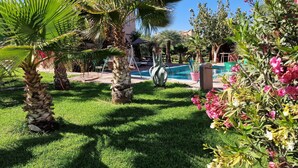 A pool area with palm trees and a clear blue sky. - Manzal Lahbab (Marrakech)
