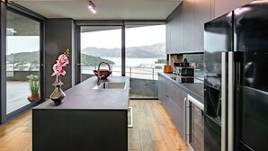 Una cocina moderna con una isla grande, electrodomésticos de acero inoxidable y vistas a las montañas.