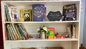 Une bibliothèque contenant divers ouvrages et deux paniers en osier.