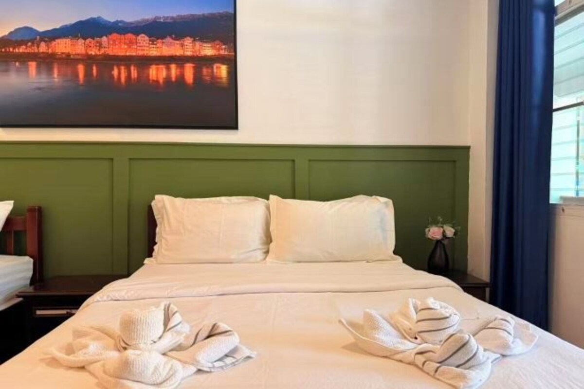 Une chambre d’hôtel avec un lit, des oreillers et des serviettes.