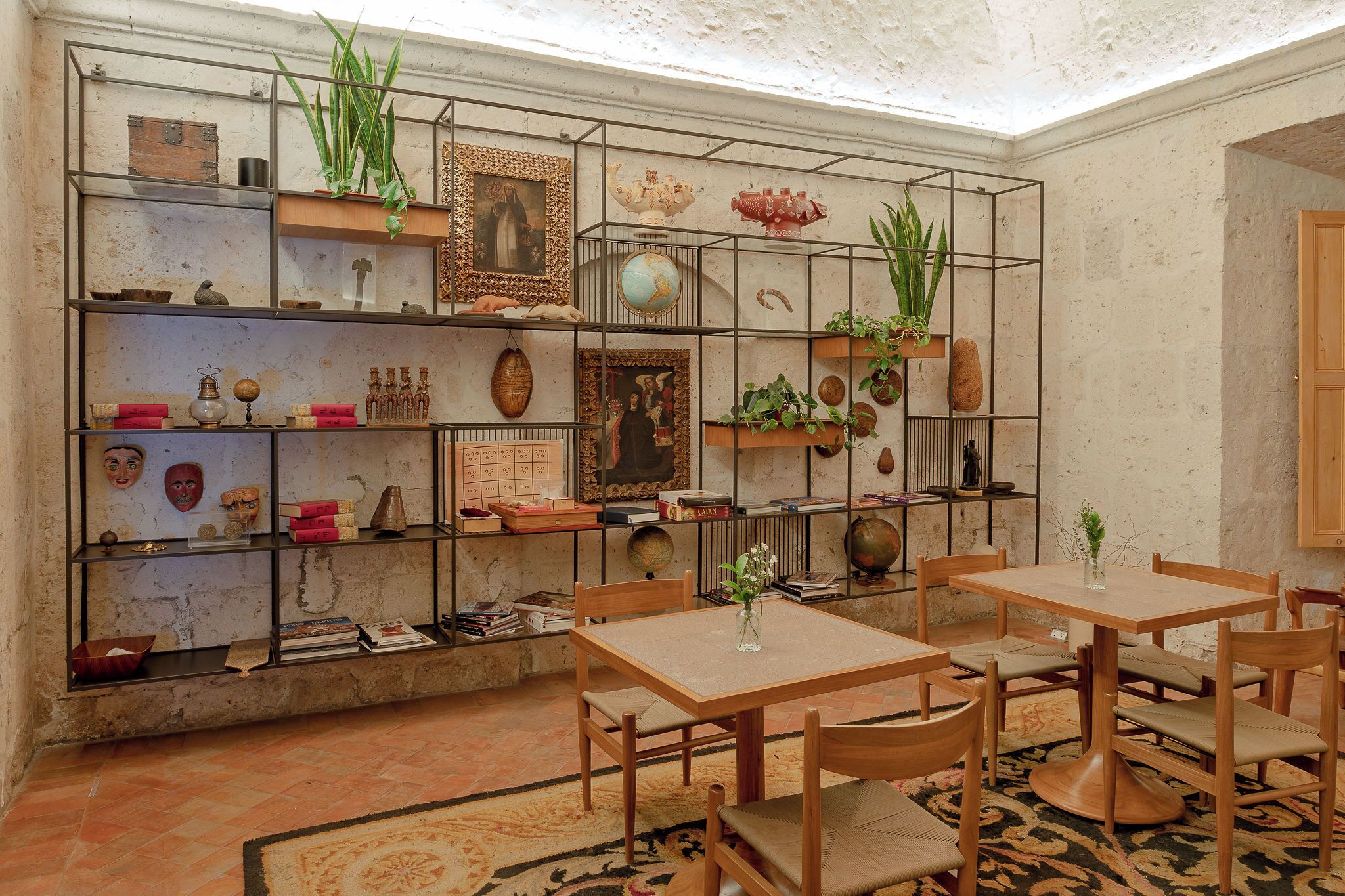 Una habitación con decoración rústica, que incluye una estantería, una mesa de madera y sillas.